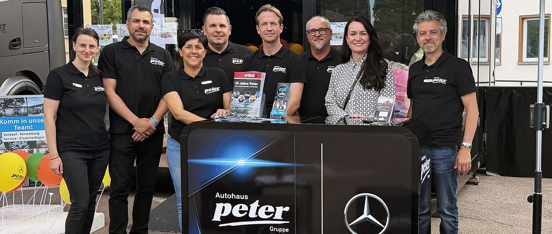 Man sieht das Team hinter einem Counter stehen beim Sachsen-Anhalt-Tag (SAT) in Bernburg.