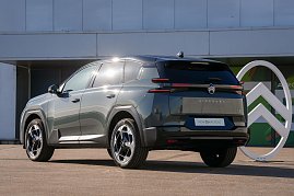 Schräg-hinten-Ansicht des neuen Citroën C5 Aircross vor einem Gebäude mit großem Citroën-Logo. (Foto: CITROËN DEUTSCHLAND GmbH)