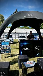 Infostand unter Pavillon: Mitarbeiter am schwarzen Mercedes-Benz Pavillon der Autohaus Peter Gruppe, im Vordergrund ein Aufsteller mit Stellenangeboten. (Foto: Autohaus Peter GmbH)