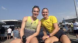 Zwei Sportlerinnen sitzen auf der Rückbank eines Mercedes-Cabrios und lächeln in die Kamera. Beide tragen Sportkleidung, die linke ein gelb-graues Top, die rechte ein gelbes Shirt. Im Hintergrund Zuschauer und Zelte beim Leichtathletikmeeting in Sondershausen. (Foto: Autohaus Peter)