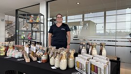 Stand mit regionalen Produkten im Autohaus Autowelt Peter. Eine Frau präsentiert dekorative Gläser mit Gewürz- und Backmischungen, Flaschen und Geschenksets, die auf einem Tisch ausgestellt sind. (Foto: Autohaus Peter)
