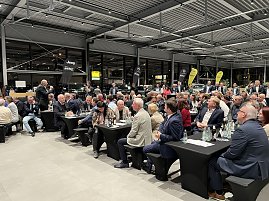 Ein gefüllter Veranstaltungsraum im Autohaus Peter: viele Anwesende sitzen an schwarzen Tischen und hören einem Redner zu. Im Hintergrund sind Fahrzeuge mit Jeep- und Citroën-Logos zu sehen.
