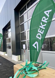 Aussenansicht den neuen Dekra Gebäudes, davor eine grüne Beachflag mit Dekra-Logo