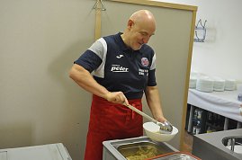 Herbert M&uuml;ller verteilt mit einer Suppenkelle die Portionen in den Sch&uuml;sseln.