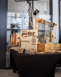 Holzschild Autowelt Peter GmbH mit Skoda- und VW-Logo an einem Schmuck- und Dekostand.