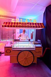 Eisverk&auml;ufer an nostalgischem Gelato-Stand mit beleuchteter Beschriftung.