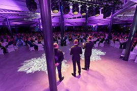B&uuml;hnenansicht mit Rednern vor gro&szlig;em Publikum bei Gala-Event.