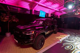 Ein schwarzer Pickup wird als Highlight-Fahrzeug inszeniert: Auf einer leicht erh&ouml;hten Pr&auml;sentationsfl&auml;che steht er unter intensiver pinker Eventbeleuchtung. Lichtprojektionen auf dem Boden.
