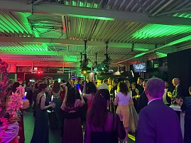 Dynamische Partyszene: Die Tanzfl&auml;che ist gut gef&uuml;llt, viele G&auml;ste feiern ausgelassen und halten leuchtende LED-Sticks in der Hand.