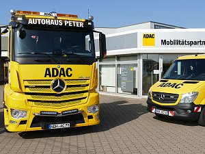 Zwei gelbe ADAC-Fahrzeuge vor dem Geb&auml;ude des ADAC Mobilit&auml;tspartners Peter in Nordhausen. Links ein gro&szlig;er Abschlepp-Lkw mit der Aufschrift "Autohaus Peter", rechts ein kleinerer Pannenhilfswagen. Im Hintergrund das moderne Geb&auml;ude mit Glasfront und ADAC-Logo.