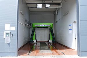 Moderne Waschanlage mit gr&uuml;nem Schriftzug �Autopflege� in einer hellen Halle, bereit f&uuml;r die Fahrzeugreinigung.