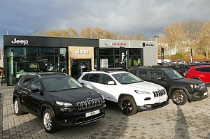 Jeep-, Dodge- und RAM-Autohaus mit moderner Glasfassade in Nordhausen, davor mehrere geparkte Jeep-Fahrzeuge in Schwarz und Weiß auf gepflastertem Hof.