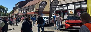 Belebte Bad Lauterberger Innenstadt bei Sonnenschein mit Besuchern und Autos der Marken Citroën, Peugeot und Opel vor Ausstellungszelten.
