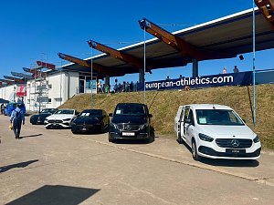 Mehrere Mercedes-Benz Fahrzeuge, präsentiert vom Autohaus Peter, stehen aufgereiht am Rand des Stadions beim Anhalt 2025 Leichtathletik-Meeting. Unter den ausgestellten Autos sind ein weißer eCitan, ein schwarzer EQV und weitere Mercedes-Modelle zu sehen. Im Hintergrund befinden sich Zuschauertribünen, ein Banner mit der Aufschrift ‚european-athletics.com‘ und einige Besucher auf dem Gelände.