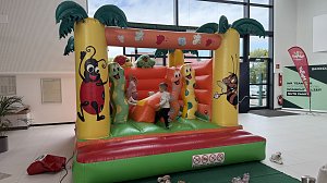 Kinder spielen auf einer bunten Hüpfburg mit Tier- und Insektenmotiven im Autohaus Autowelt Peter. Die Hüpfburg ist Teil des Familienprogramms zur Feier von 130 Jahren Škoda.