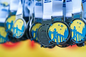 Finisher-Medaillen des Erfurter Nachtlaufs 2026 mit L&auml;ufermotiv und Erfurter Stadtsilhouette