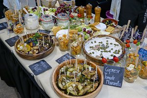 Ein reichhaltiges Buffet, das mit verschiedenen kleinen Vorspeisen, Salaten, eingelegtem Gem&uuml;se und Dip-Schalen samt kleinen Beschriftungstafeln angerichtet ist.