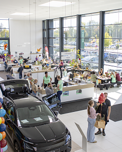 Blick von oben auf den gut besuchten Showroom der Autowelt Peter mit Škoda Fahrzeugen, herbstlichen Marktständen und Kreativangeboten.