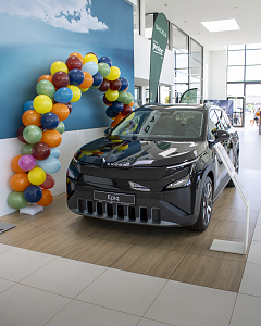 Schwarzer Škoda Epiq in einem hellen Autohaus, dekoriert mit einem Bogen aus bunten Luftballons.