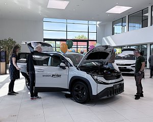 Weißer Škoda Epiq mit geöffneter Motorhaube und Türen während einer Fahrzeugpräsentation im Showroom der Autowelt Peter.