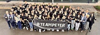 Gruppenfoto der 63 neuen Auszubildenden der Autohaus-Peter-Gruppe vor dem Mercedes-Benz-Autohaus in Nordhausen. Alle tragen schwarze #TeamPeter-T-Shirts und halten einen Banner mit dem Schriftzug #TEAMPETER. Geschäftsführung und Ausbildungsleitung stehen am Rand, alle lächeln und zeigen Daumen hoch. (Autohaus Peter)