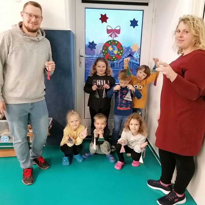 Kita-Leiter Markus Klaan und Erzieherin Victoria Wedler sind stolz auf ihre kleinen Künstler. Alle zeigen die gebastelten Bäumchen.