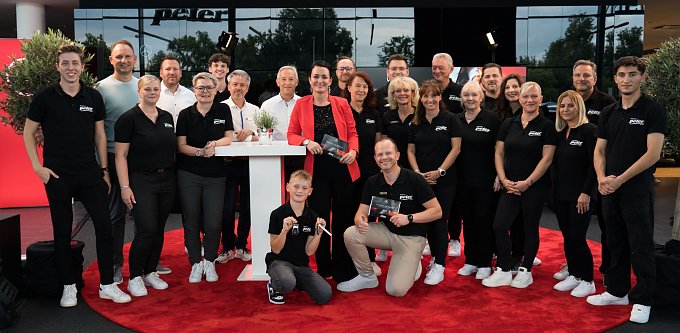Teamfoto mit 24 Personen vom Autohaus Peter beim Hes Mercedes Abend. Die meisten tragen schwarze Polohemden mit Peter-Logo, alle lächeln in die Kamera.